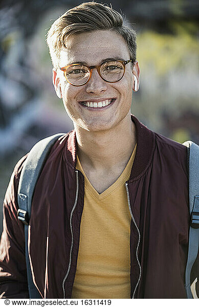Lächelnder gut aussehender junger Mann mit Brille