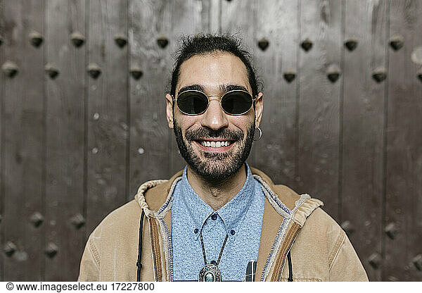 Lächelnder Hipster-Mann vor der Tür stehend