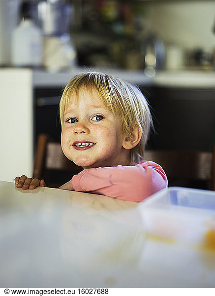 Lächelnder Junge lehnt an Küchentheke
