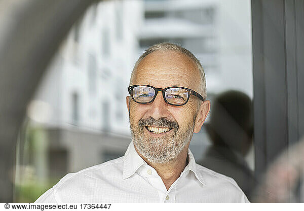 Lächelnder älterer männlicher Berufstätiger mit Brille