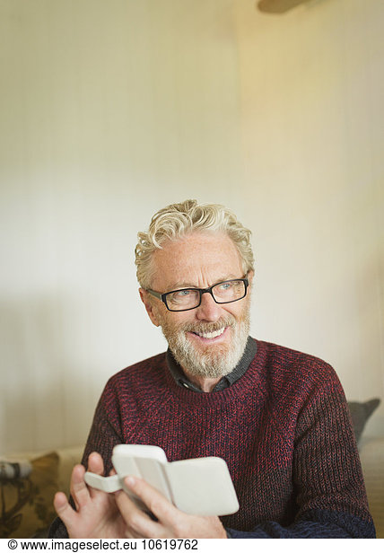 Lächelnder älterer Mann SMS mit Handy