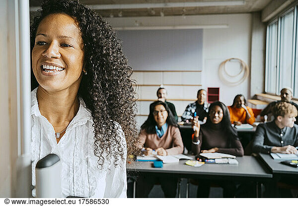 Lächelnder Professor unterrichtet Universitätsstudenten im Klassenzimmer