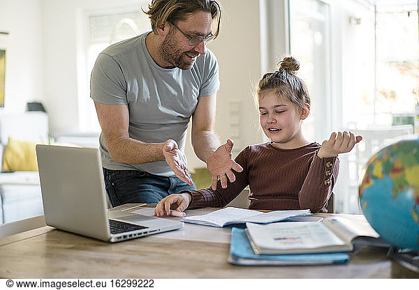 Lächelnder Vater unterrichtet Tochter zu Hause