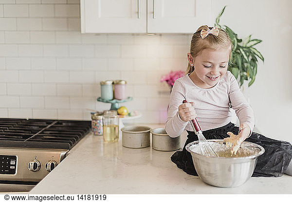 Lächelndes Mädchen beim Backen auf der Küchentheke