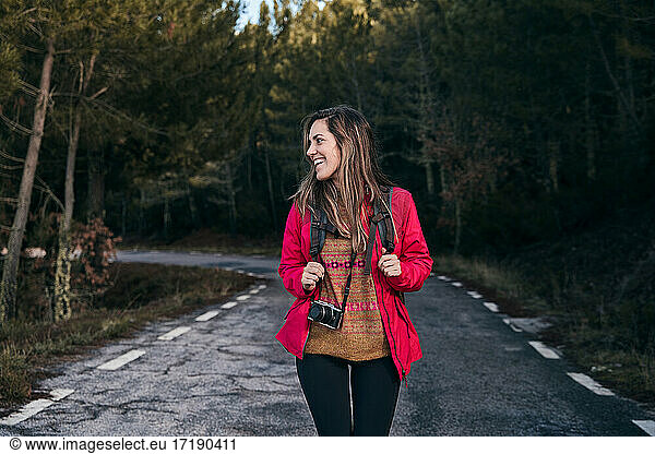 Lächelndes Mädchen mit Rucksack in der Natur zu Fuß durch den Wald. Entspannung Zeit im Urlaub Konzept Reisen  selektive und weichen Fokus  Hipster-Stil Farbton