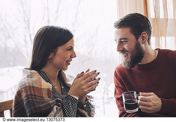 Lächelndes Paar  das sich bei einem Drink im Cafe anschaut