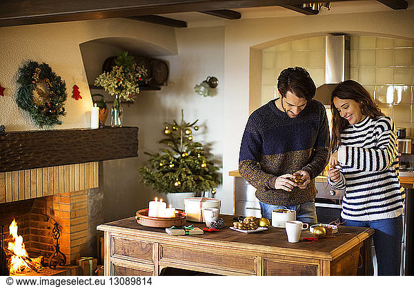 Lächelndes Paar schmückt zu Weihnachten sein Zuhause