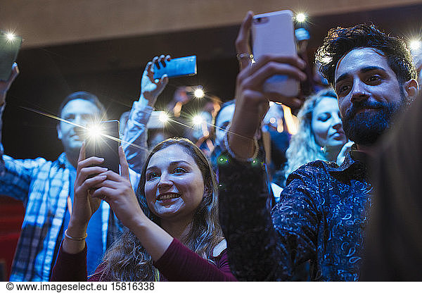 Lächelndes Publikum mit Smartphone-Taschenlampen