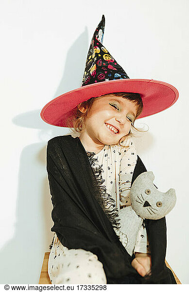 Lächelndes süßes Mädchen als Halloween-Hexe gekleidet