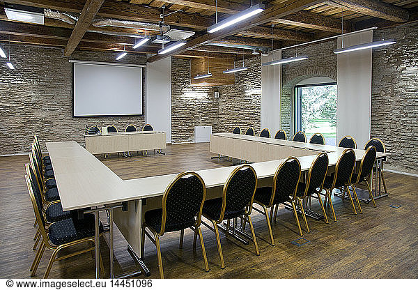 L-förmiger Tisch und Projektionswand im Konferenzraum