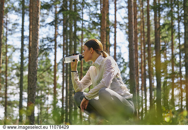 Läufer ruht Trinkwasserflasche im Wald