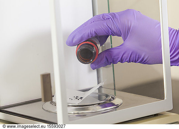 Laboratory scientist measuring a precision amount of indigo on precision scale