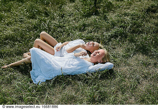 Lachende Dorfkinder im Gras liegend