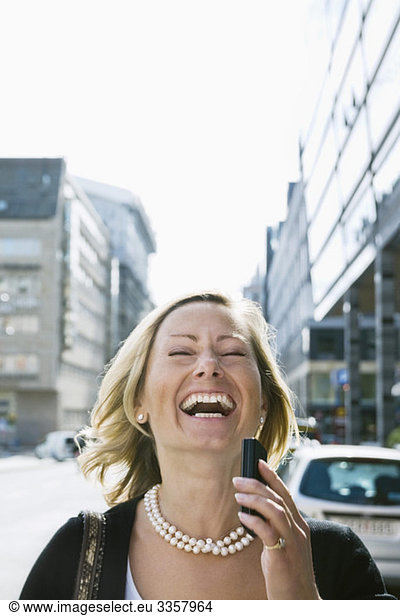 Lachende Geschäftsfrau im Gespräch mit dem Handy