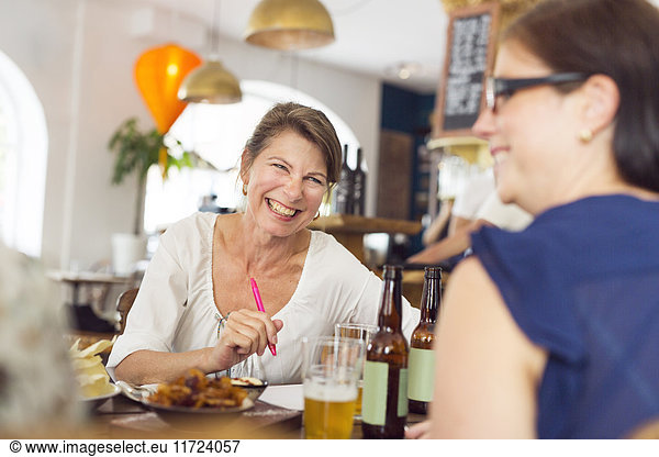 Lachende Geschäftsfrauen beim Mittagessen im Restaurant