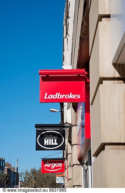 Ladbrokes and William Hill betting shop signs England UK.