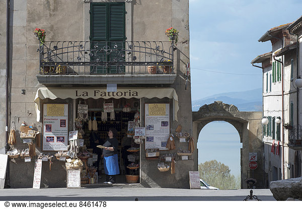 Laden mit lokalen Spezialitäten  hinten Stadttor und See  Piazza Mazzini  Altstadt  Castiglione del Lago  Umbrien  Italien