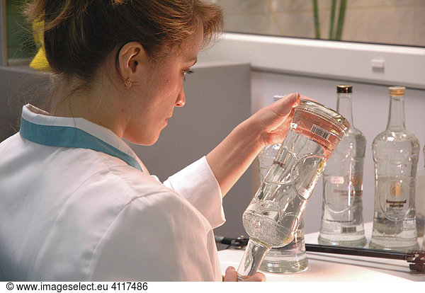 Lady checks wodka bottle at Ladoga wodka plant  St. Petersburg  Russia