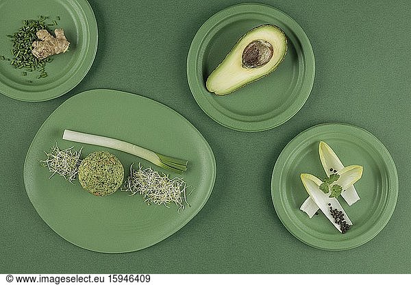 Laid table in green  plate with dumplings  spinach dumplings  avocado  chives  cress  leek  ginger  still life  food photography  studio photography  Italy  Europe