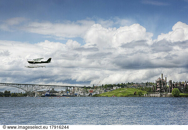 Lake Union  Washington State  a town on the coast  a factory and bridge  and a sea plane in mid air.