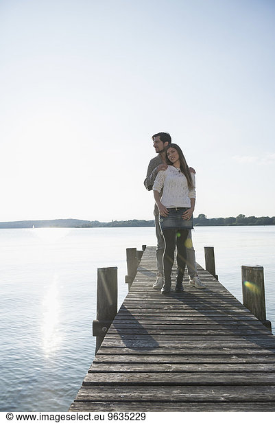 Lake water jetty young couple sunset