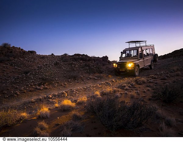 Landrover fährt im Kulala Wilderness Reserve  Namib-Wüste in der Dämmerung  Tsarisberge  Region Hardap  Namibia  Afrika