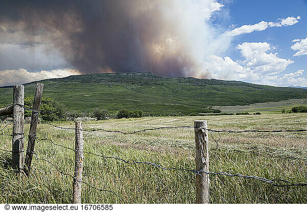 Landscape with smoke emitting from wildfire in background