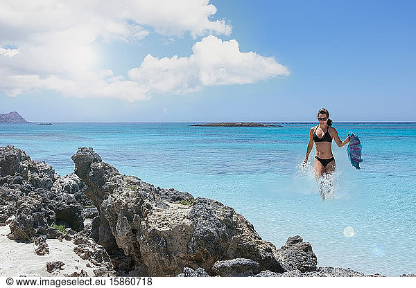 Landscape with woman at seaside beach rocks and turquoise clear