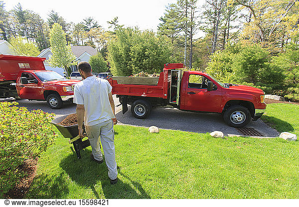 Landschaftsgärtner transportiert Mulch von einem Lastwagen