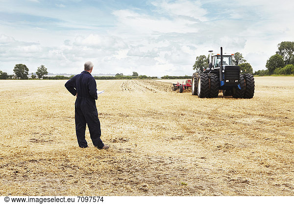 Landwirt mit Blick auf Traktor im Ackerbau