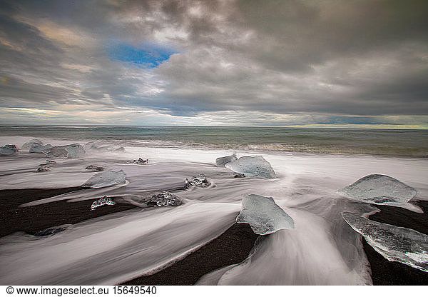 Lange Fensterläden aus Weiß  das über schmelzende Eisberge rauscht  Strand von Jokulsarlon  Island