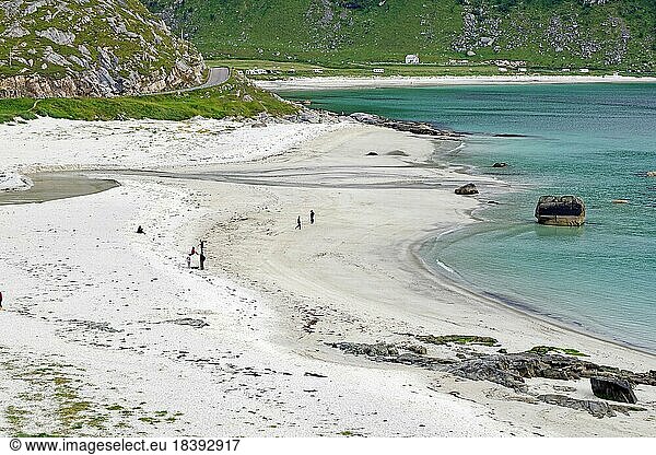Langer  weißer Sandstrand mit glasklarem Wasser  einzelne Menschen spazieren am Strand  Tourismus  Haukland  Austvagsoya  Provinz Nordland  Norwegen  Europa
