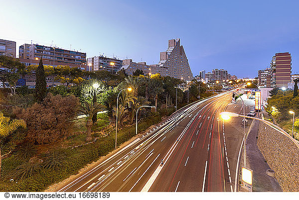 Langzeitbelichtung in der Abenddämmerung in einer Straße mit viel Verkehr in Alicante.