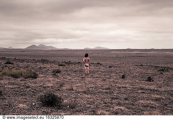Lanzarote  Caleta de Famara  Rückansicht eines nackten Mannes in trostloser Landschaft