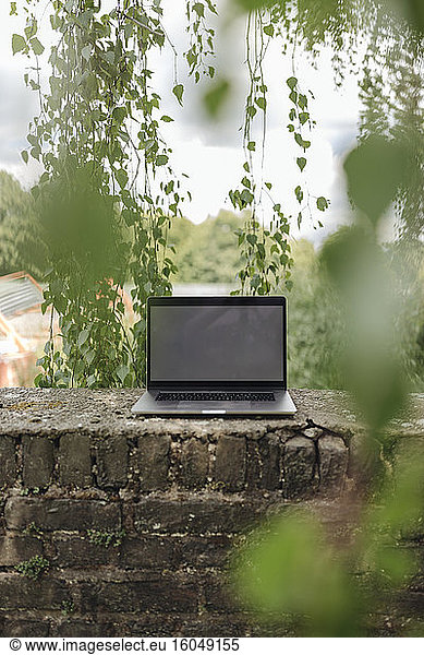 Laptop an einer Backsteinmauer auf dem Lande