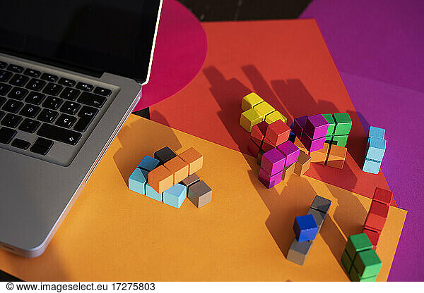 Laptop and colorful blocks on table at home