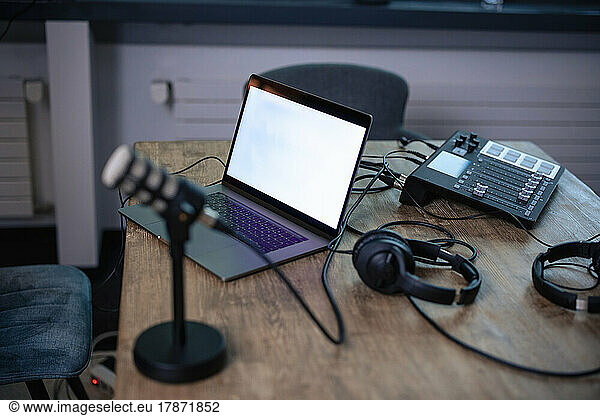 Laptop by headset on desk in radio station
