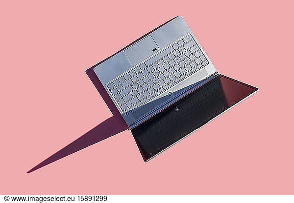 Laptop on pink background