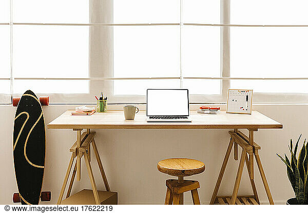 Laptop on table in front of window at home