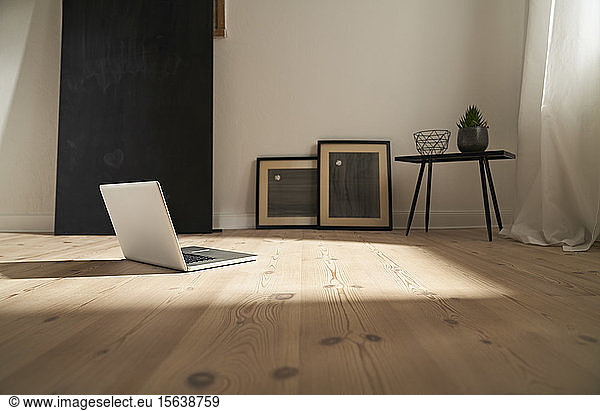 Laptop on wooden floor in a modern room