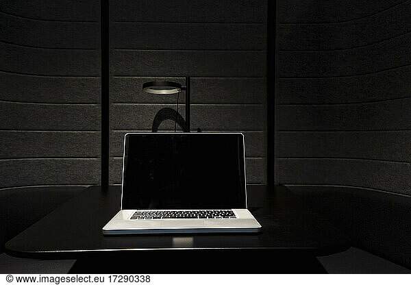 Laptop placed on black desk in office