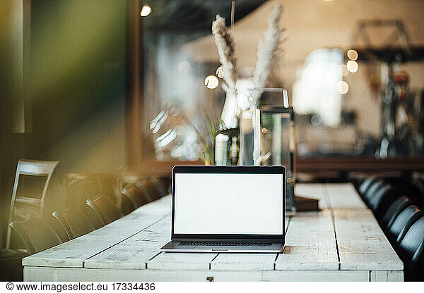 Laptop with blank screen on cafe table