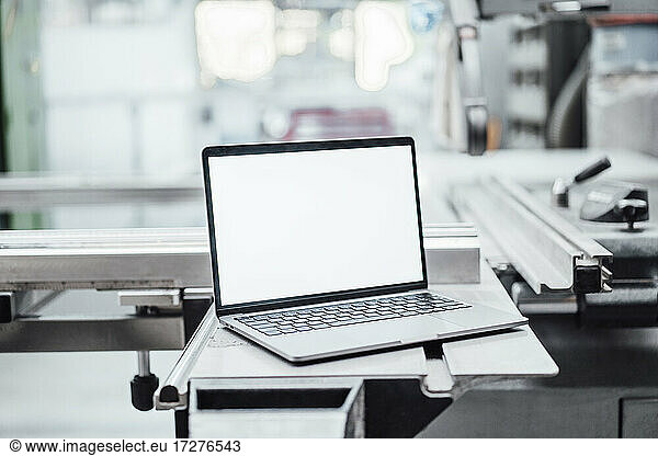 Laptop with blank screen on machinery in factory