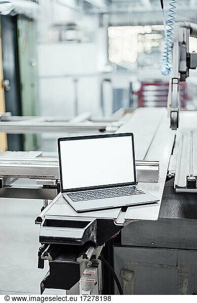 Laptop with blank screen on manufacturing equipment in industry