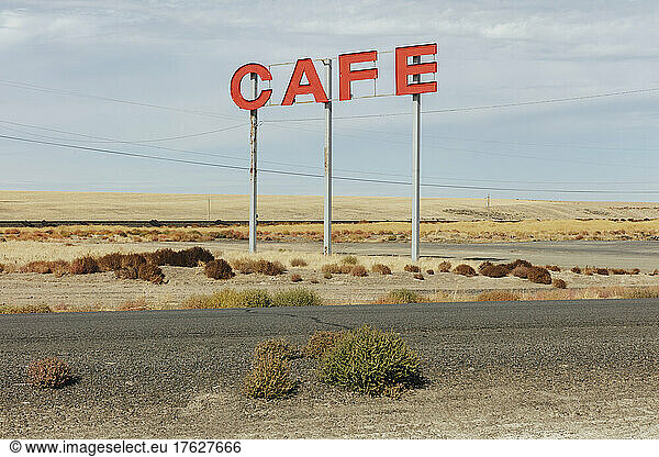 Large CAFE sign over rural farmland.