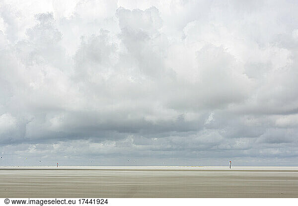 Large clouds over vast empty beach