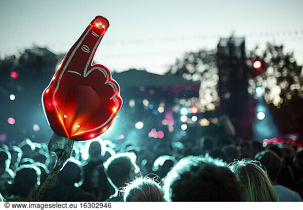 Large foam hand over crowd of people having fun during music festival