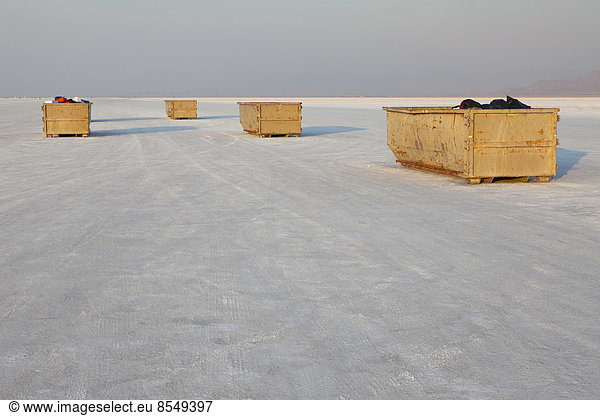 Large garbage containers on salt flats  dusk
