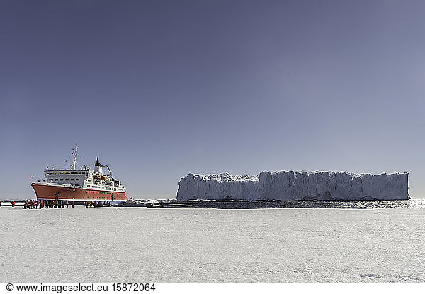 Large iceberg and expedition ship against sea ice  Antarctica  Polar Regions