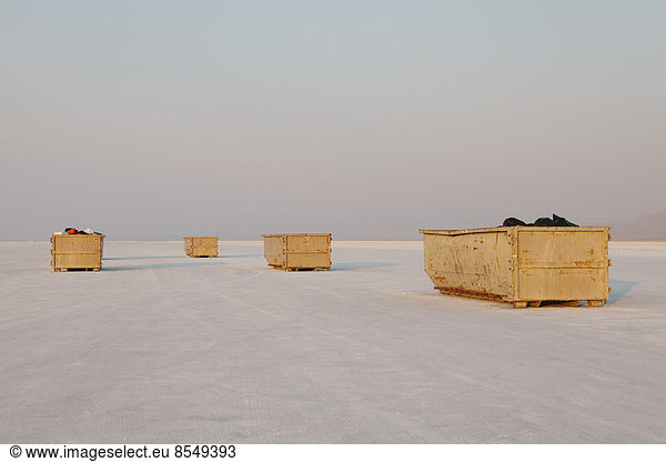 Large yellow garbage containers on Bonneville Salt Flats  dusk  near Wendover.